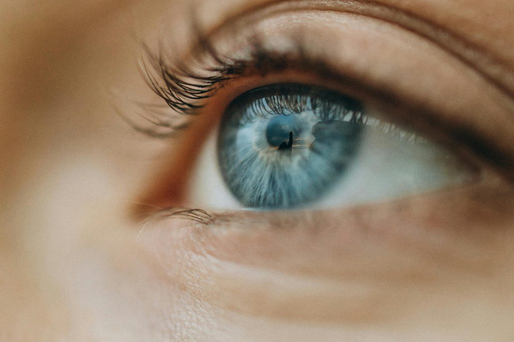Macro shot of a blue eye highlighting intricate details and eyelashes.